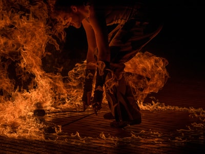 男子火舞演员，手持两支火把，被火包围